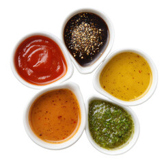 Variety of colorful dipping sauces arranged in small dishware for snacks or appetizers at a casual dining setting