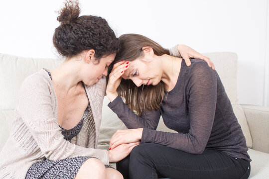 Two women embrace during a moment of grief and distress, symbolizing empathy, compassion, emotional support, and solidarity in times of pain or trauma.