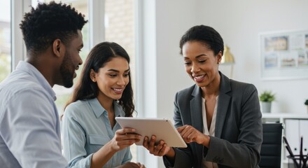 A real estate agent shows a digital tablet to a couple, discussing property details in an office setting.
