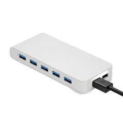 A modern, light gray device with multiple USB ports is angled toward the viewer, showcasing its sleek design and connectivity features.