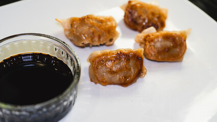 Delicious fried juicy dumpling (gyoza) glazed with rich tare sauce or soy sauce, crispy on the...