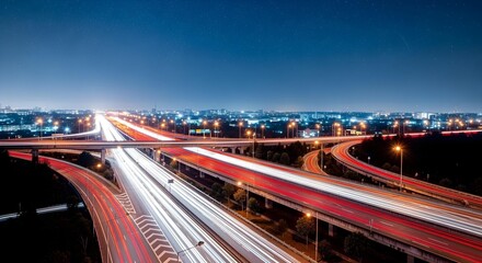 Obraz premium Long exposure of a highway interchange seen from above with streams of red and white light