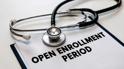 Professional stethoscope rests on important document announcing open enrollment period for healthcare benefits and medical coverage opportunities
