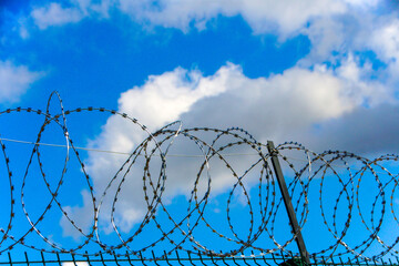 A wire fence with barbed wire on top of it.