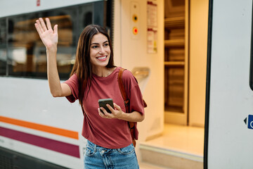 Young Woman Using Phone In A Subway Station