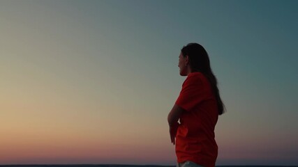 Beautiful girl dancing and having fun with friends at sunset disco. Young smiling woman dancing against sky outdoors. Cheerful woman moving her hands to music at party. Holiday party. Party on beach - Powered by Adobe