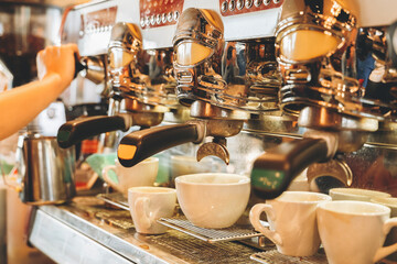 Barista prepares espresso drinks at a vibrant cafe during morning rush with polished machines and...