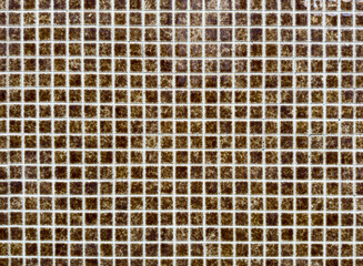 Mosaic tile pattern forms geometric grid. Small square ceramic brown tiles create textured