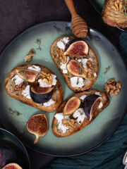 Vertical Close-Up of Three Fig and Goat Cheese Toasts with Honey and Walnuts