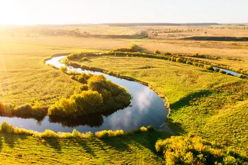 Selbstklebende Fototapeten Honig Serene meandering river carves through the landscape during golden hour. Location place Polissya region, Ukraine.  © Leonid Tit