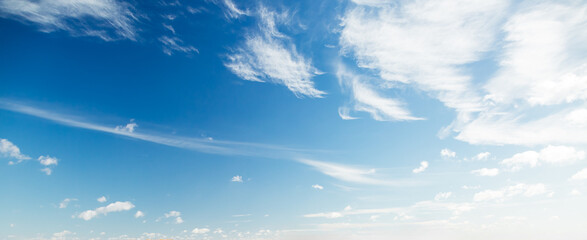 A serene view of the sky filled with white cirrus clouds against a vivid blue backdrop.