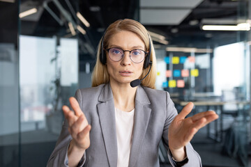 Businesswoman in headset talking during online video call via webcam