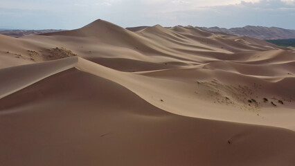 Aerial view of sand dunes in desert at sunset