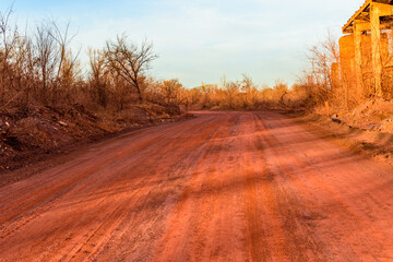 Red dirt road polluted with the iron ore. Environmental pollution