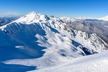 Mountain peak, snowy slopes, and clear sky