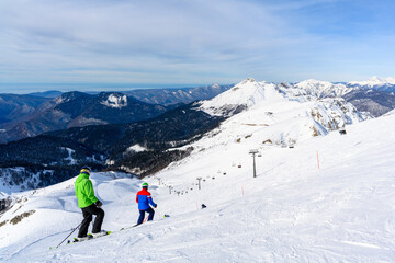 A ski slope with skiers surrounded by a winter forest