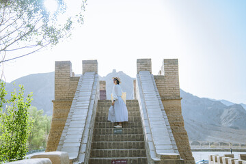 Naklejka premium woman traveling in Overhanging Great Wall in Jiayuguan, China. The west end of the Great Wall of China in Summer. 
