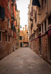 Naklejka premium Narrow Venetian alley with historic walls