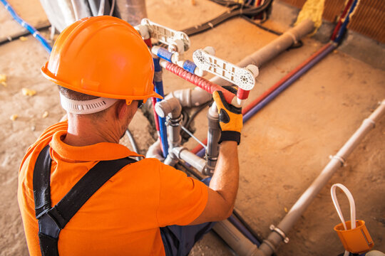 Skilled Technician Working on Plumbing Installation in a Modern Building