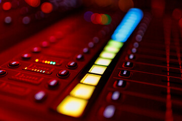 Illuminated audio mixing console with glowing buttons and sliders