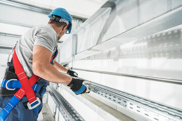 Worker Installing Equipment in a Modern Industrial Facility During Daylight