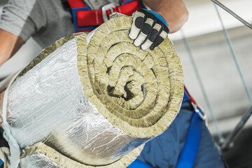 Worker Carrying Insulation Material in a Construction Site During the Day