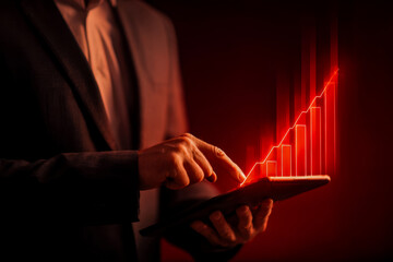 Business professional analyzing growth data on a tablet with rising financial graph