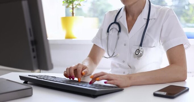 doctor typing on computer keyboard, working at clinics office. medical consultation and support, hospital help desk, reception