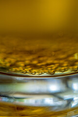 Close-up of golden beer with bubbles at bottom of glass