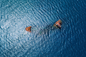 An aerial view of the Manassa Rose shipwreck in Crete, Greece, split into two sections with rusted...