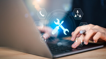 IT support and digital tools concept. Person using laptop with glowing wrench and screwdriver ,...