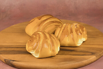 Colorful freshly baked homemade bread rolls on a wooden board with copy space in the foreground