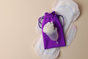 Eco-friendly menstrual cup and other feminine hygiene products on a bright background