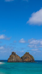 Fototapeta premium Registro vertical dos icônicos Morro Dois Irmãos em Fernando de Noronha, símbolo natural e turístico. Noronha, PE