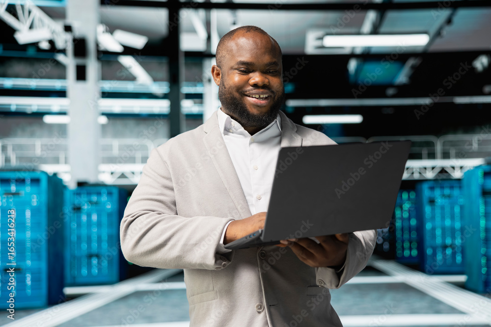 Poster happy programmer in server farm overseeing mainframes devices used for managing databases. cheerful 