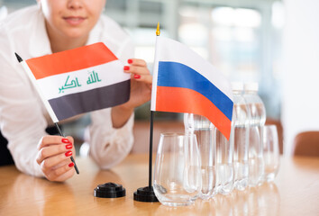 Unrecognizable woman preparing room for international negotiations and communication discussions of...