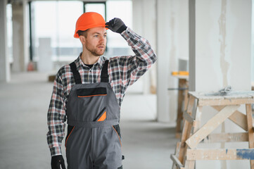 Construction worker adjusting helmet in building under construction