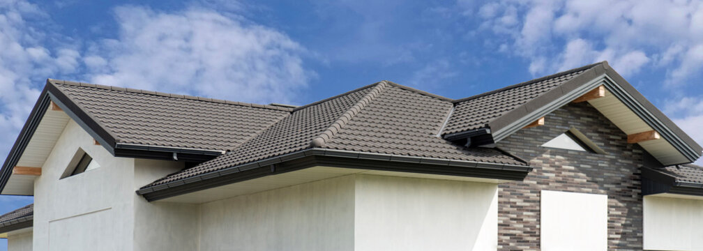 Gray composite roof tile with wave profile on modern house