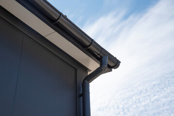 Plastic gutter with curved downspout