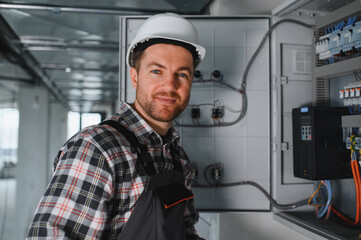 Electrician repairing electrical panel in building under construction