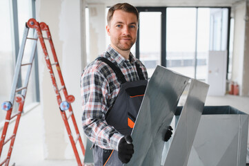 Hvac technician installing ventilation system in building under construction