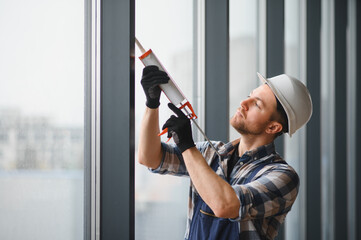 Construction worker sealing window frame with silicone gun