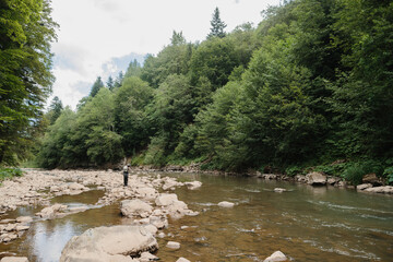 Fisherman catching trout in a pristine mountain river