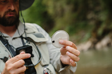 Fisherman checking fishing line while trout fishing in river