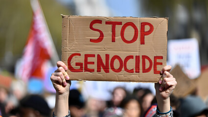 Hands and a Sign: A Close Shot of a Protester at a Rally with a Bold Banner.