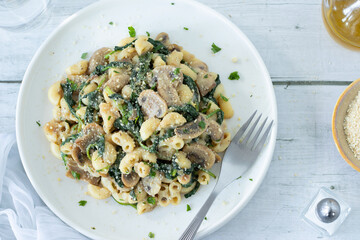 Mushroom spinach pasta with vegan parmesan cheese. Top view.