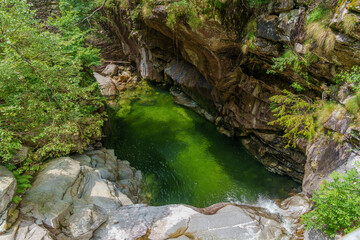 tranquil emerald pool nestled among rugged rocks and vibrant greenery, illustrating the pristine...
