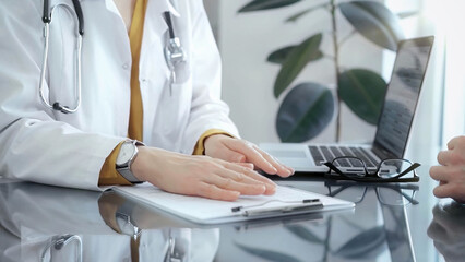 Doctor and patient consultation with clipboard and medication notes. Close-up view of unknown...