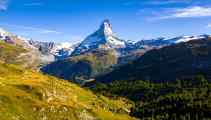 Fototapeta premium Majestic Matterhorn: Aerial View of Swiss Alps, Sunny Day, Lush Green Valley, Snow-Capped Peaks, Serene Landscape Photography.