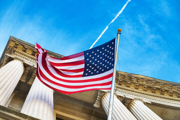 Historic neoclassical facade with waving USA flag in Washington, showcasing democracy, politics,...